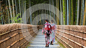 Young Japanese woman in a taditional Kimono dress strolls by the Bamboo Grove at Adashino Nenbutsuji Temple in Kyoto, Japan