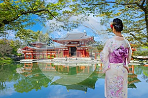 Young Japanese Woman in Traditional Kimono Dress at the Phoenix Hall of Byodo-in Temple in Kyoto, Japan