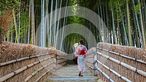 Young Japanese woman in a traditional Kimono dress strolls by the Bamboo Grove at Adashino Nenbutsuji Temple in Kyoto, Japan