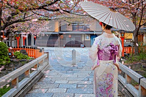 Young Japanese woman in traditional Kimono dress at Tatsumi bashi bridge over Shirakawa river in Gion district, Kyoto