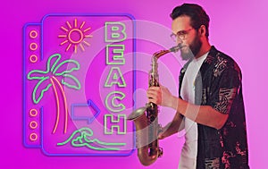Young jazz musician playing the saxophone in neon light with neon sign