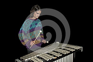 Young jazz musician playing the vibraphone in his private rehearsal room. Black background. photo