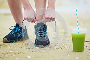 Young jogger with green vegetable smoothie