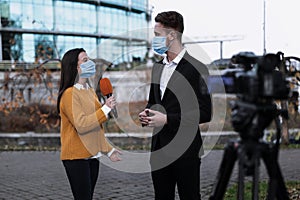 Young journalist and businessman with medical masks. Virus protection