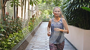 Young joyful woman running in summer day. Healthy way of life.