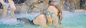 Young joyful woman under the water stream, pool, day spa, hot springs BANNER, LONG FORMAT