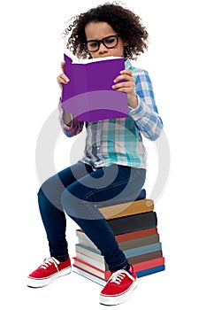 Young kid concentrating while reading a book