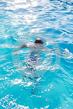 Young kid diving in swimming pool outdoors