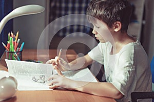 Young kid doing homework or learning at home