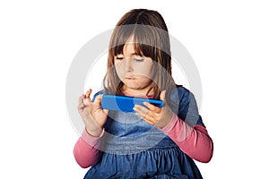 Young kid, four years old playing with her cell phone. early technology addiction concept. bad habits