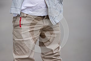 A young kid peeing on his pants on the street - Bed-wetting concept. Child pee on clothes photo