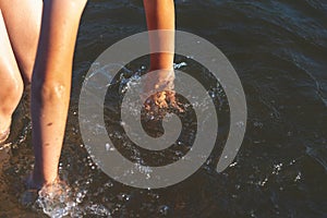 Young kid play in water and making splash boy to prepare in lake or river and have fun with drops.Closeup