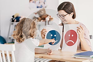 Young kid pointing at graphic with a smiley face during a psycho photo