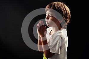 Young kid in a spiritual peaceful moment praying