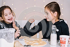 Young kids baking Christmas gingerbread cookies in house kitchen on winter day.Kids playing with flour