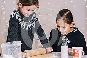 Young kids baking Christmas gingerbread cookies in house kitchen on winter day.Kids playing with flour