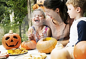 Young kids carving Halloween jack-o`-lanterns