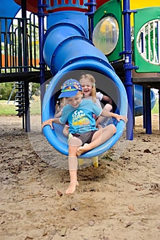 Young kids exiting a tube slide