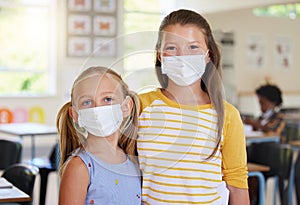 Young kids learning in classroom, after covid pandemic, wearing face masks together in school. Portrait of little girl