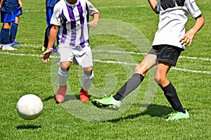 Young kids are playing soccer in summer time