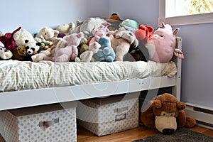 Young kids room with cute plush toys on bed and simple, easy storage baskets underneath