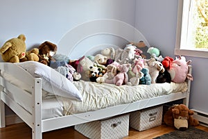 Young kids room with cute plush toys on bed and simple, easy storage baskets underneath