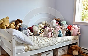 Young kids room with cute plush toys on bed and simple, easy storage baskets underneath