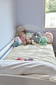 Young kids room with cute plush toys on bed and simple, easy storage baskets underneath