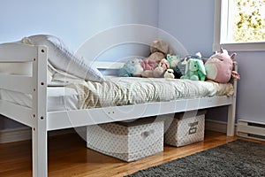 Young kids room with cute plush toys on bed and simple, easy storage baskets underneath