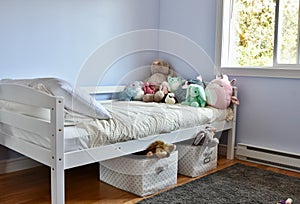 Young kids room with cute plush toys on bed and simple, easy storage baskets underneath