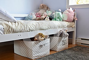 Young kids room with cute plush toys on bed and simple, easy storage baskets underneath