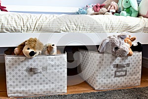 Young kids room with cute plush toys on bed and simple, easy storage baskets underneath