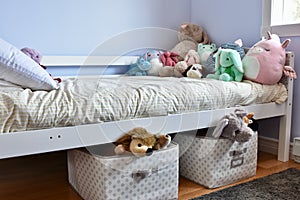 Young kids room with cute plush toys on bed and simple, easy storage baskets underneath