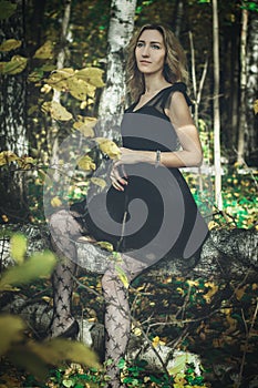 A young kind witch in a black dress with a black mask in a mystical forest in various poses. Art processing