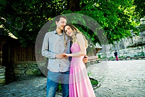 Young kissing couple under big tree with swing