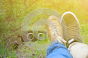 Young kissing happy couple in love sitting on the ground and listening music in green sammer park