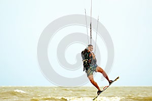 Young kitesurfer jumping in the sky on the board