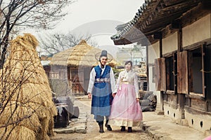 Young Korean couple in hanbok wolking in the park