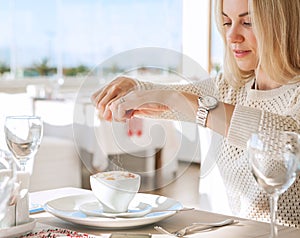 Young lady added sugar in coffee photo