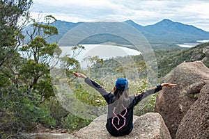 Young lady admiring scenery of Eaglehawk Neck with open arms at Tasmania, Australia.