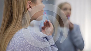 Young lady applying lipstick before date, altering appearance by make up