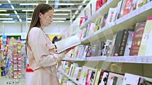 Young lady is buying a book in a store