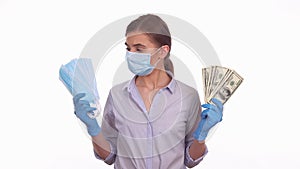 Young lady choosing between sterile medical mask and dollar money