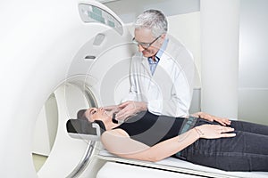 Young lady with the doctor in the room of computed tomography at hospital