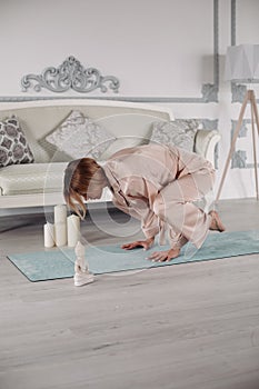 Young lady doing gymnastics on floor at home