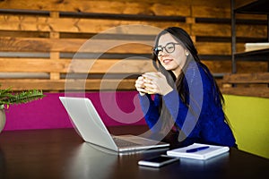 Young lady drink coffee at her working space in modern office