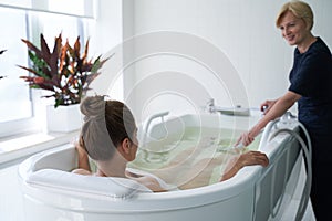 Young lady enjoying hydromassage in whirlpool bath