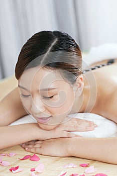 A young lady enjoying stone massage at spa