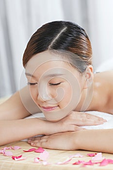 A young lady enjoying stone massage at spa