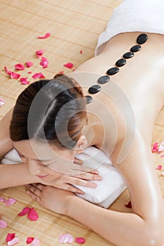 A young lady enjoying stone massage at spa